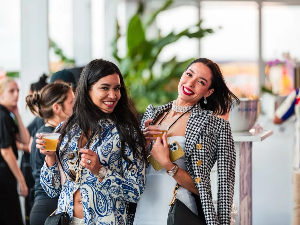 Two guests laughing together, drinks in hand